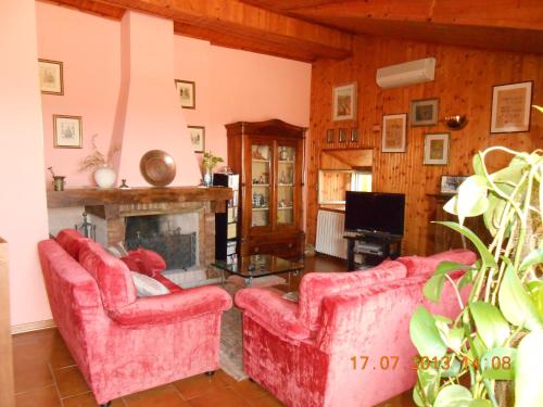 a living room with two red couches and a fireplace at B&B La Pilastrina in Maranello