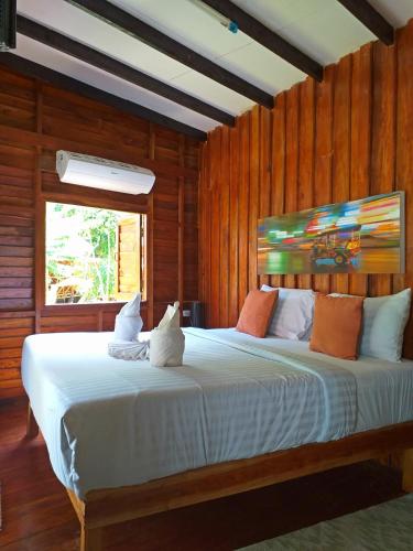 two cats sitting on a bed in a room at The Ford SunSet Beach Resort in Wok Tum