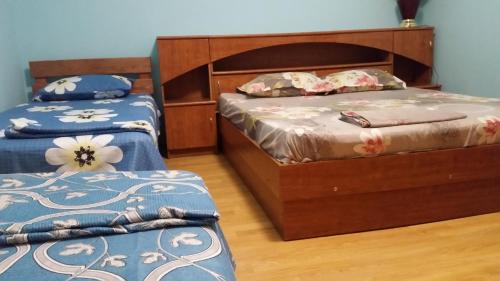 ヴォロネジにあるMini-Hotel Mazda Club on Dunayskaya 1Aのベッドルーム1室(青と白のシーツが備わるベッド2台付)