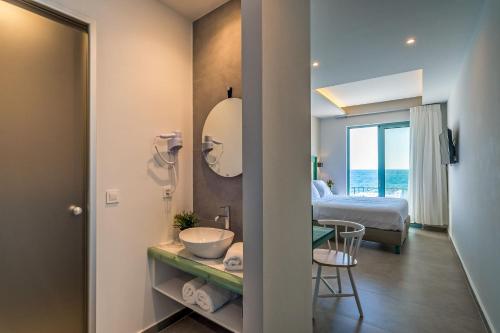 a bathroom with a sink and a bed and a mirror at Samaria by the Sea in Khóra Sfakíon