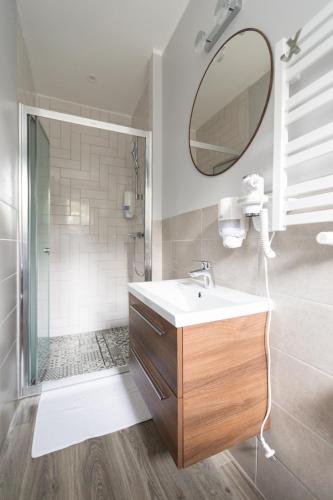 a bathroom with a sink and a mirror and a shower at Rafa przy Plaży in Sztutowo