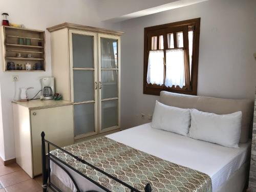 
a bedroom with a bed and a dresser at Niriides in Ammouliani
