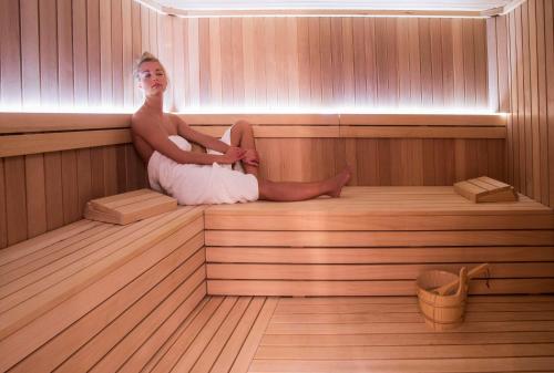 a woman is sitting in a sauna at Esplanade Zagreb Hotel in Zagreb