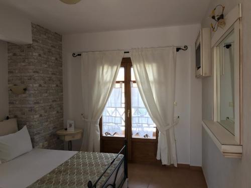 
a bedroom with a bed and a window at Niriides in Ammouliani
