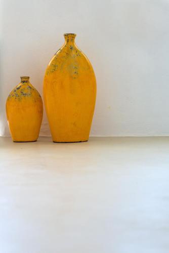 two orange vases sitting next to a white wall at Samaria by the Sea in Khóra Sfakíon