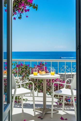 a table and chairs on a balcony with the ocean at Samaria by the Sea in Khóra Sfakíon