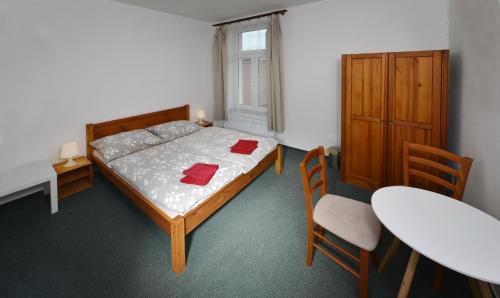 a bedroom with a bed and a table and chairs at Penzion Pivovar Podlesí in Příbram