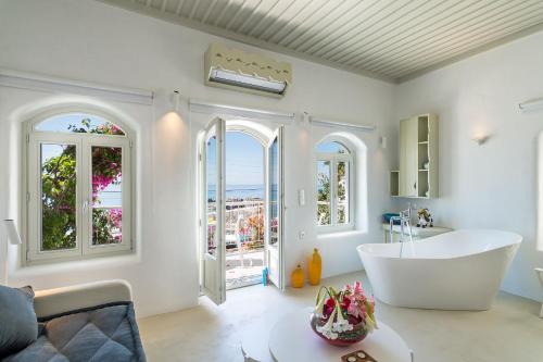 Habitación con ventanas y baño con bañera grande. en Samaria by the Sea en Khóra Sfakíon