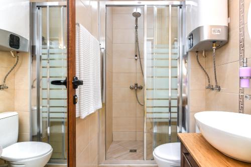 a bathroom with a shower and a toilet and a sink at The Cozy Apartment in Varna City