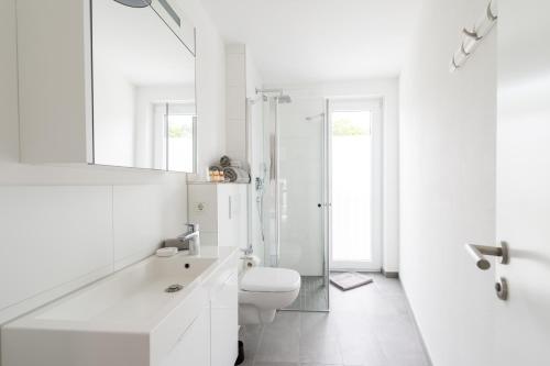 een witte badkamer met een toilet en een douche bij Ferienwohnung Universität in Tübingen