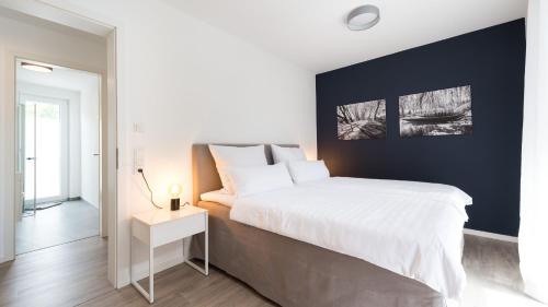 Un dormitorio con una gran cama blanca y una mesa en Ferienwohnung Universität en Tübingen