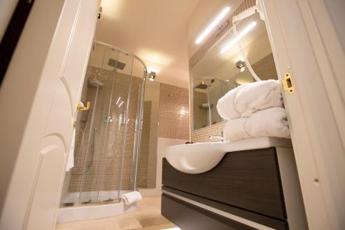 a bathroom with a sink and a shower with towels at Portercole B&B in Tropea