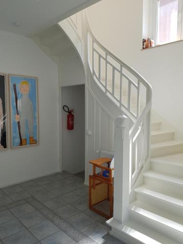a white staircase in a room with a painting at Haus Roy in Zülpich