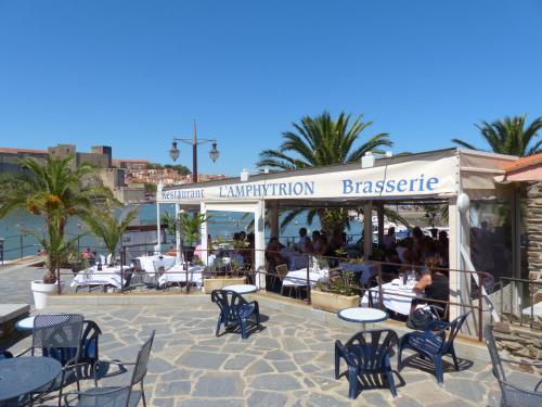 a restaurant with chairs and tables and people sitting in it at Hôtel Triton in Collioure