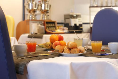 - une table avec des assiettes de fruits et des boissons dans l'établissement Kyriad Direct Rennes Ouest, à Vezin-le-Coquet