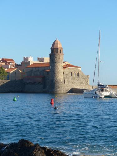 a harbor with a sail boat and a castle at Hôtel Triton in Collioure
