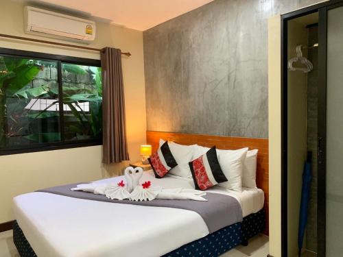 - une chambre avec un grand lit et des draps blancs dans l'établissement Isayarada Apartment, à Thalang