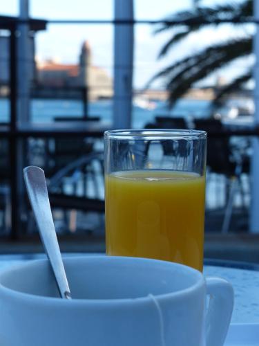 a cup of orange juice next to a bowl of orange juice at Hôtel Triton in Collioure