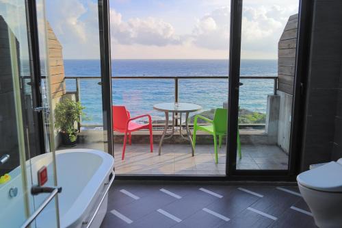 a bathroom with a balcony with a table and chairs at Jing Guan Hotel in Eluan