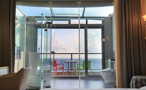 a room with a large glass door with a view of the ocean at Jing Guan Hotel in Eluan