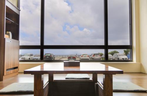 a living room with a table and a large window at Jing Guan Hotel in Eluan