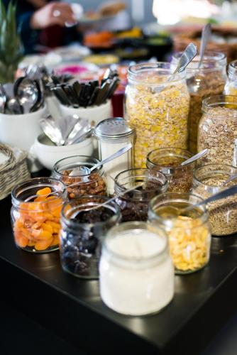 a table with many jars of different types of food at Maude´s Hotel Enskede Stockholm in Stockholm