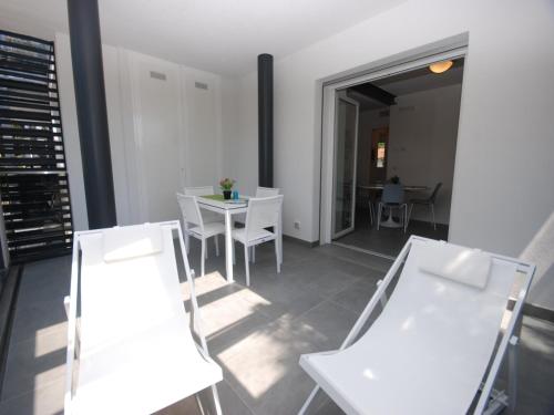 a living room with white chairs and a table at Due Perle in Lignano Sabbiadoro