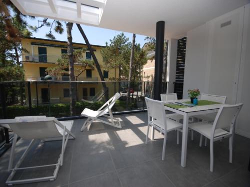 a patio with a table and chairs on a balcony at Due Perle in Lignano Sabbiadoro