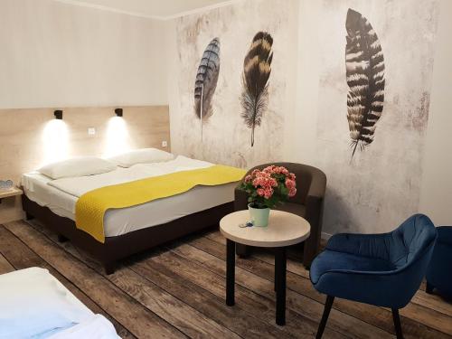 a bedroom with a bed and a table and chairs at Erdővarázs Panzió in Lillafüred