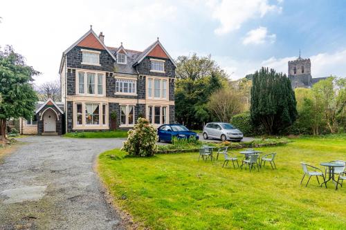 a large house with tables and chairs in the yard at Dolafon Guest House in Llanberis