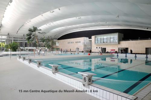 a large swimming pool in a large building at Charmant F2 à Vémars- Parc Astérix - Mer de Sable - Villepinte - Aéroport CDG in Vémars