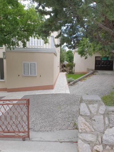 a building with a gate in front of a house at Apartman Dora in Šmrika