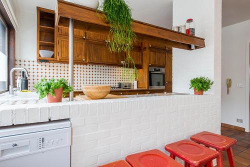 a kitchen with a counter with red stools at Vintage Duplex in Bruges in Bruges