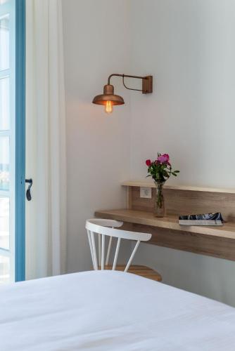 a bedroom with a table with a vase of flowers at Livikon by the Sea in Khóra Sfakíon