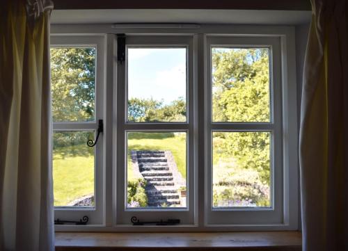 ein offenes Fenster mit Blick auf eine Treppe in der Unterkunft Burnhaies Farm Coach House in Cullompton