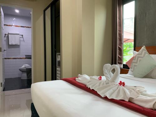 a hotel room with two beds with towels on them at Isayarada Apartment in Thalang