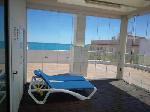a blue chair on a balcony with a view of the ocean at Marjal 3 Beach in Guardamar del Segura
