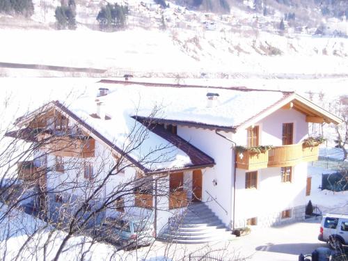 a white house with snow on the roof at Villa Golf in Pinzolo