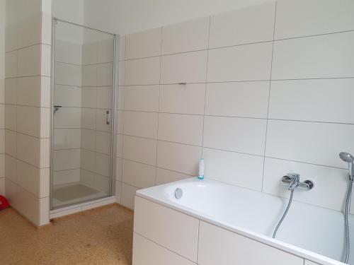 La salle de bains blanche est pourvue d'une douche et d'une baignoire. dans l'établissement Haus Roy, à Zülpich