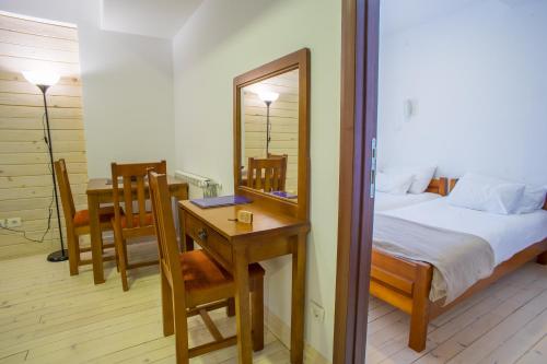 a bedroom with a bed and a table and a mirror at Hotel Polar Star in Žabljak
