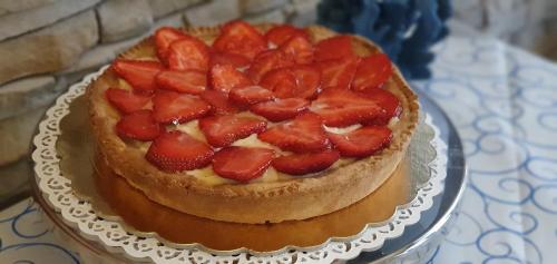 a cake with strawberries on top on a table at Ines bed and breakfast in Giardini Naxos
