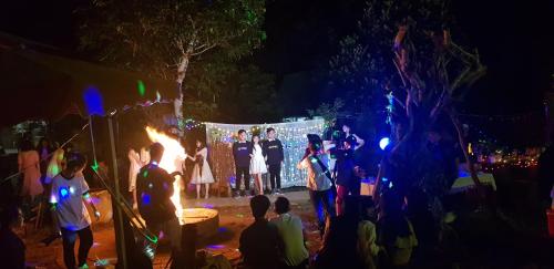 a group of people standing on a stage at night at Garden Homestay in Di Linh
