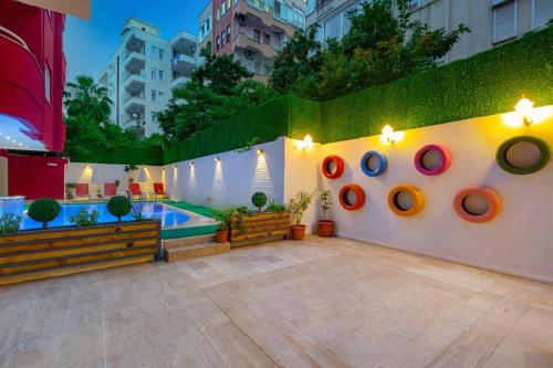 a courtyard with a pool and a wall with donuts at Twin Apart Hotel in Alanya