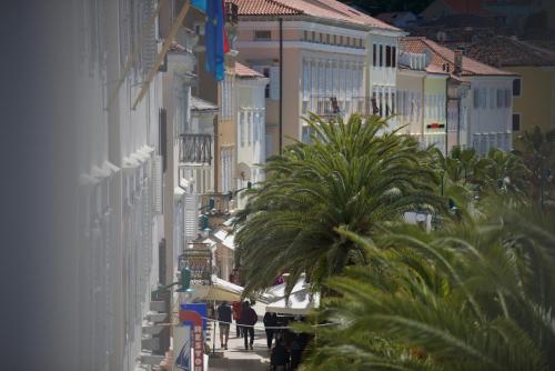 a group of people walking down a city street at Apartments and Rooms Jospino in Mali Lošinj
