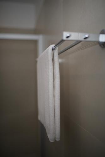 a white towel hanging on a towel rack in a bathroom at Apartments and Rooms Jospino in Mali Lošinj
