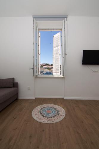 an empty living room with a window and a rug at Apartments and Rooms Jospino in Mali Lošinj