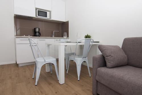 a kitchen with a table and two chairs and a couch at Apartments and Rooms Jospino in Mali Lošinj