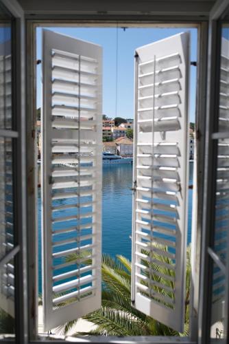 a window with a view of a body of water at Apartments and Rooms Jospino in Mali Lošinj