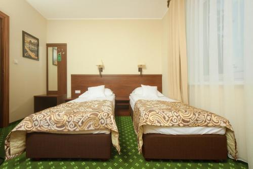 a hotel room with two beds in a room at Hotel Zielony in Poznań