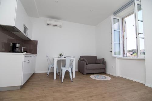 a kitchen and dining room with a table and a chair at Apartments and Rooms Jospino in Mali Lošinj
